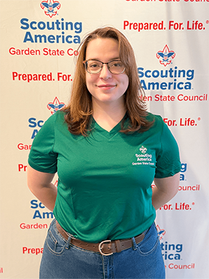 Alexia B. smiling in a Scouting America polo shirt in front of a Garden State Council backdrop.