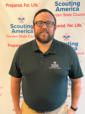 Brian D. smiling in front of a Scouting America Garden State Council backdrop.
