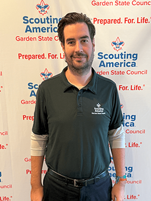 Javier J. smiling in front of a Scouting America Garden State Council backdrop.