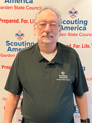 Joseph B. wearing a Garden State Council polo shirt in front of a Scouting America backdrop.