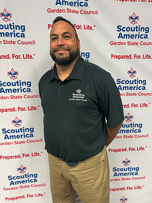 Omar C. smiling in front of a Scouting America Garden State Council backdrop.