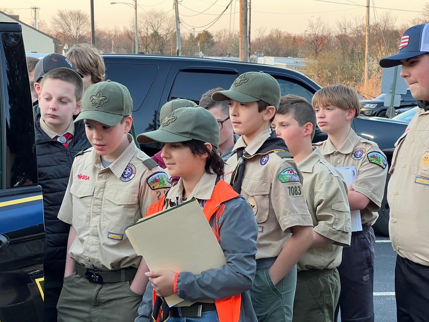 Group of Scouts in uniform gathered together outdoors during a community activity.
